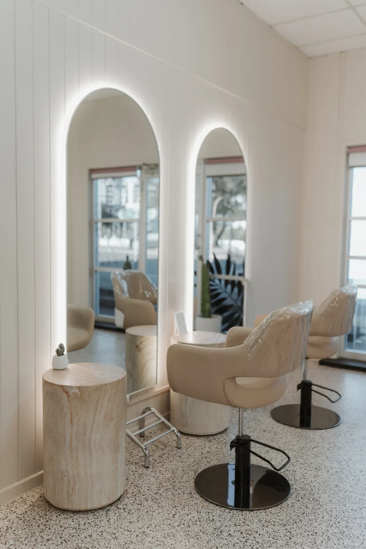 Backlit arched mirrors and stylist stations
